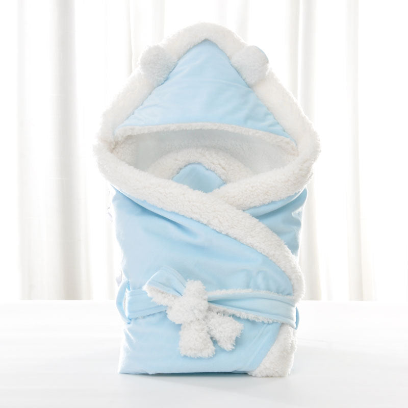 Newborn baby being hugged and swaddled by baby