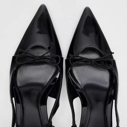 Black patent leather bow with pointed tip thin heel and a shallow strap for women's sandals